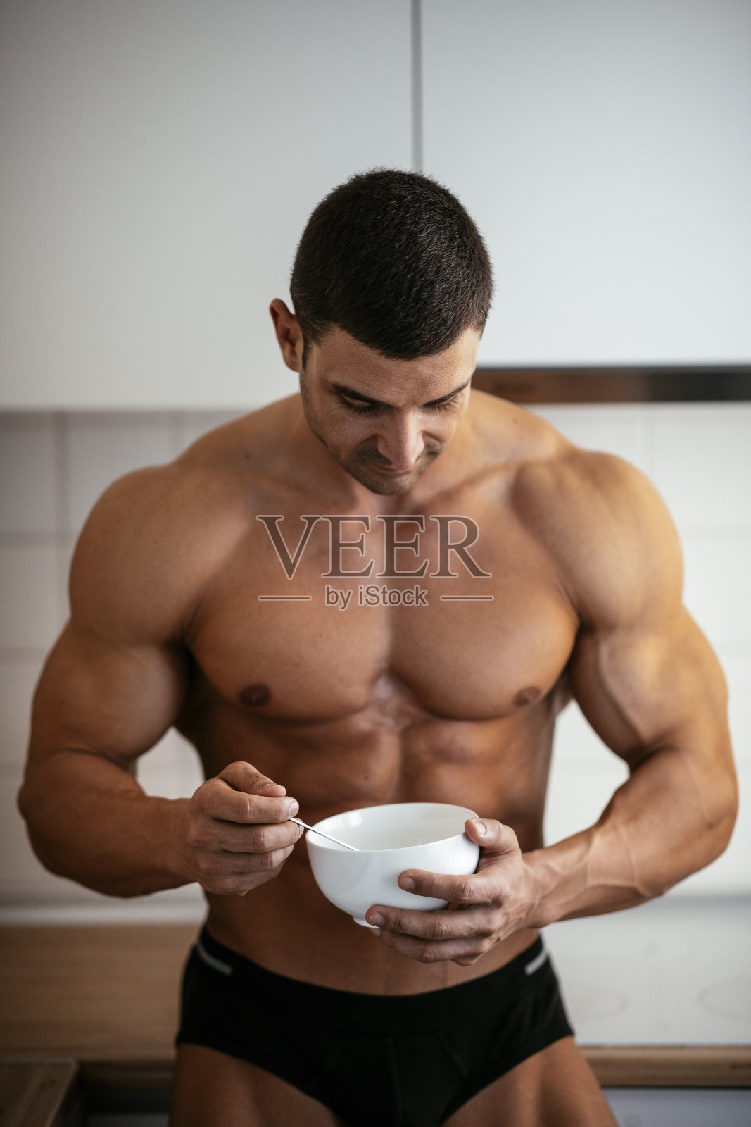 英俊的肌肉男早餐吃麦片照片摄影图片