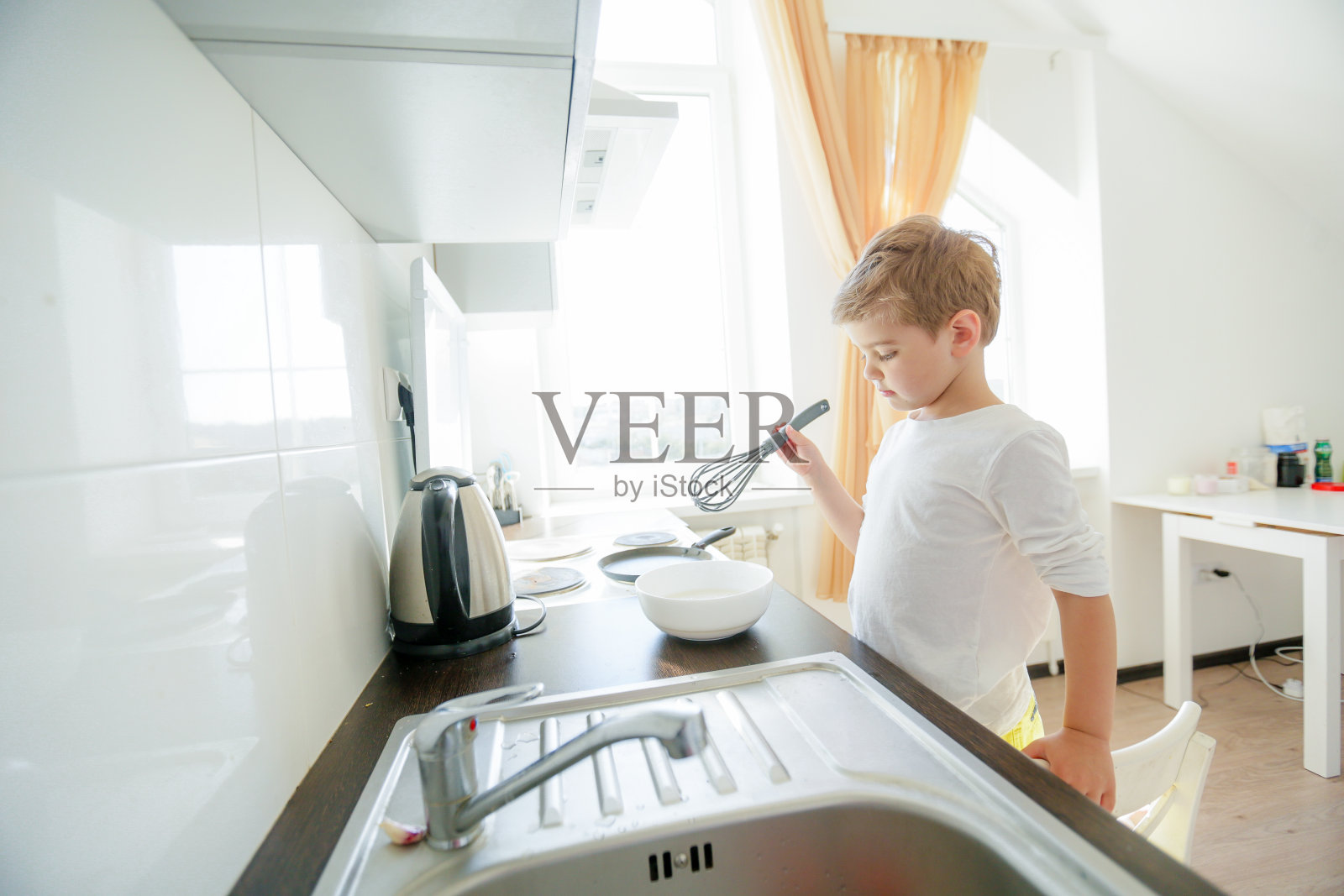 搞笑的欧洲小男孩厨师跳舞,周末快乐,男孩想做煎饼,但煎锅太gay了,他决定拿着木头勺子在他的手中玩得开心,在做饭的时候玩得开心照片摄影图片