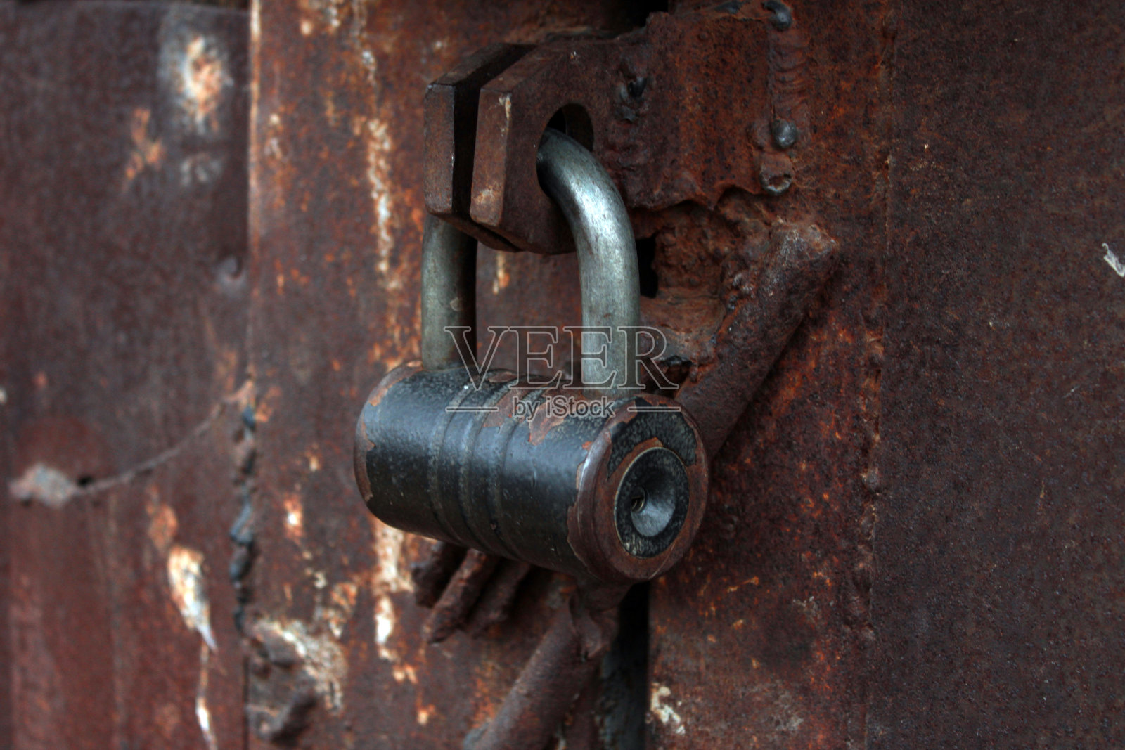 关上生锈的大型金属车库门,锁上。照片摄影图片