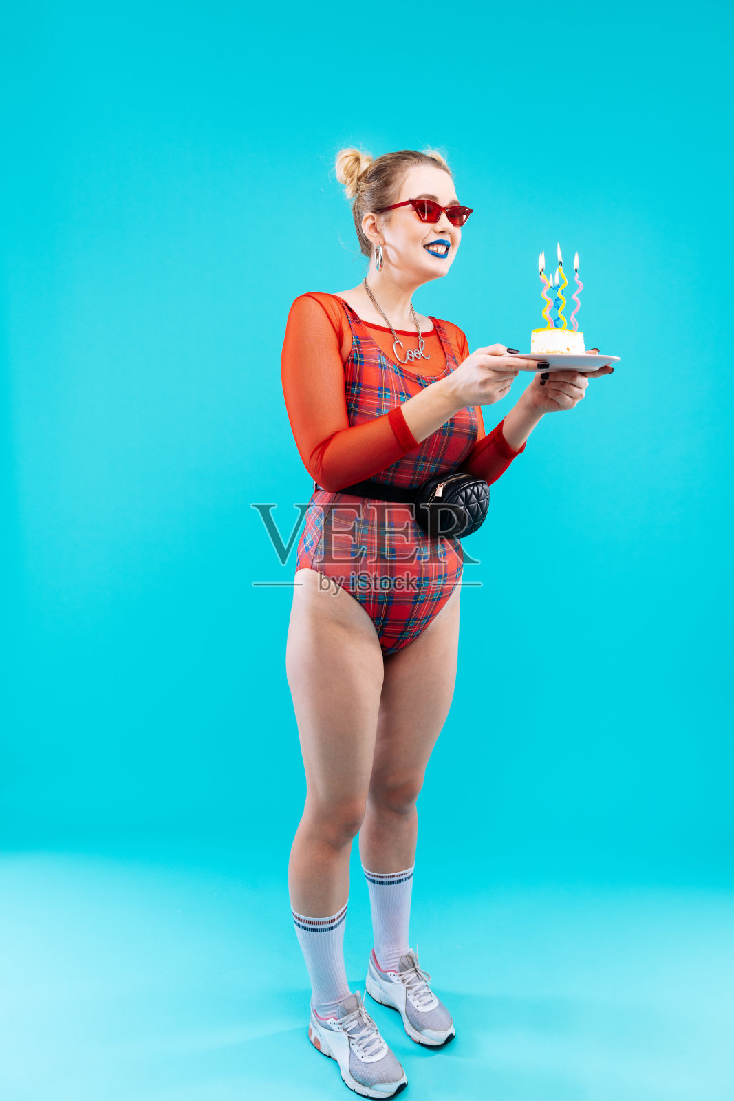 穿着红色紧身衣的女人拿着盛着生日蛋糕的盘子照片摄影图片