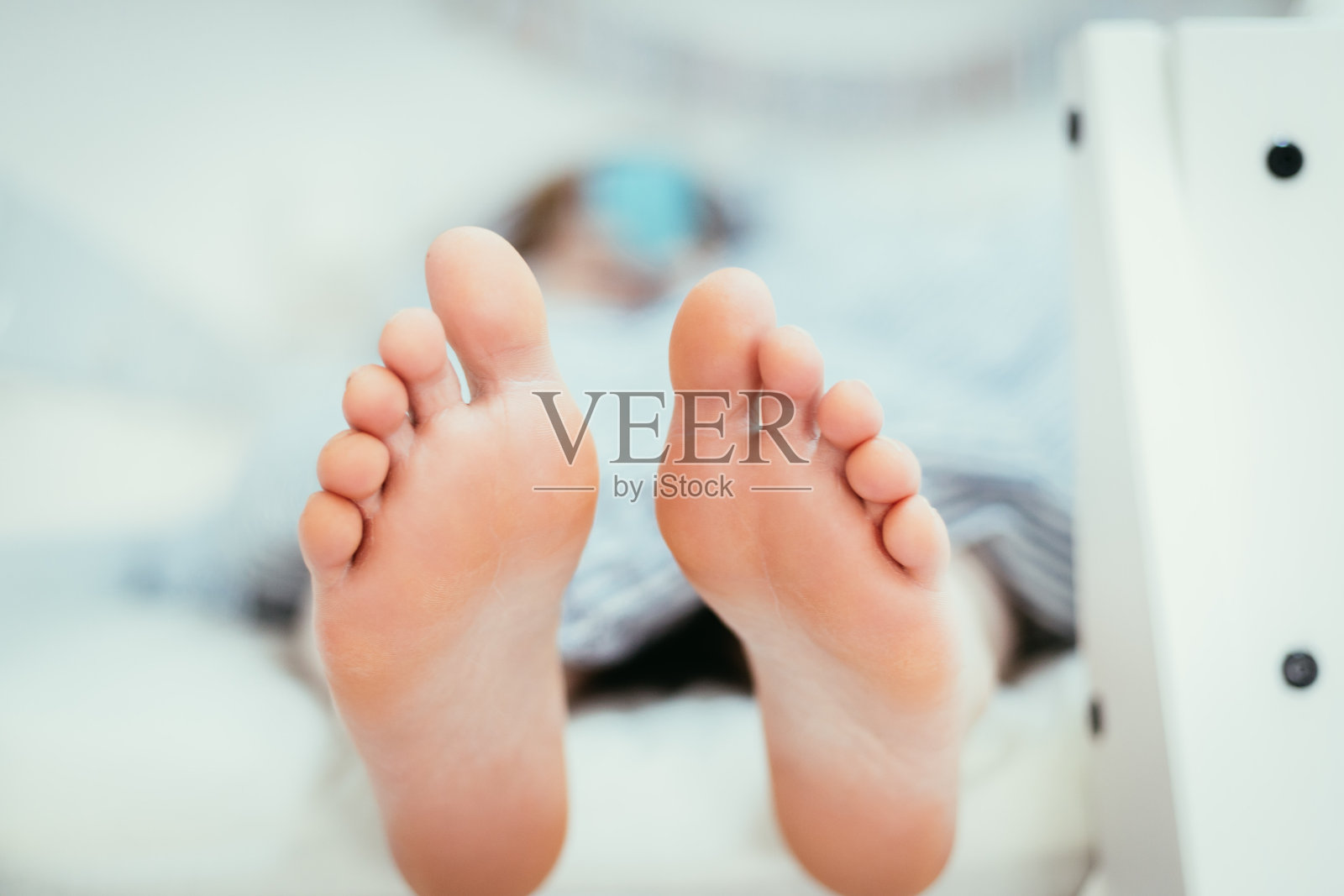 早上,一个女孩光着脚躺在床上照片摄影图片