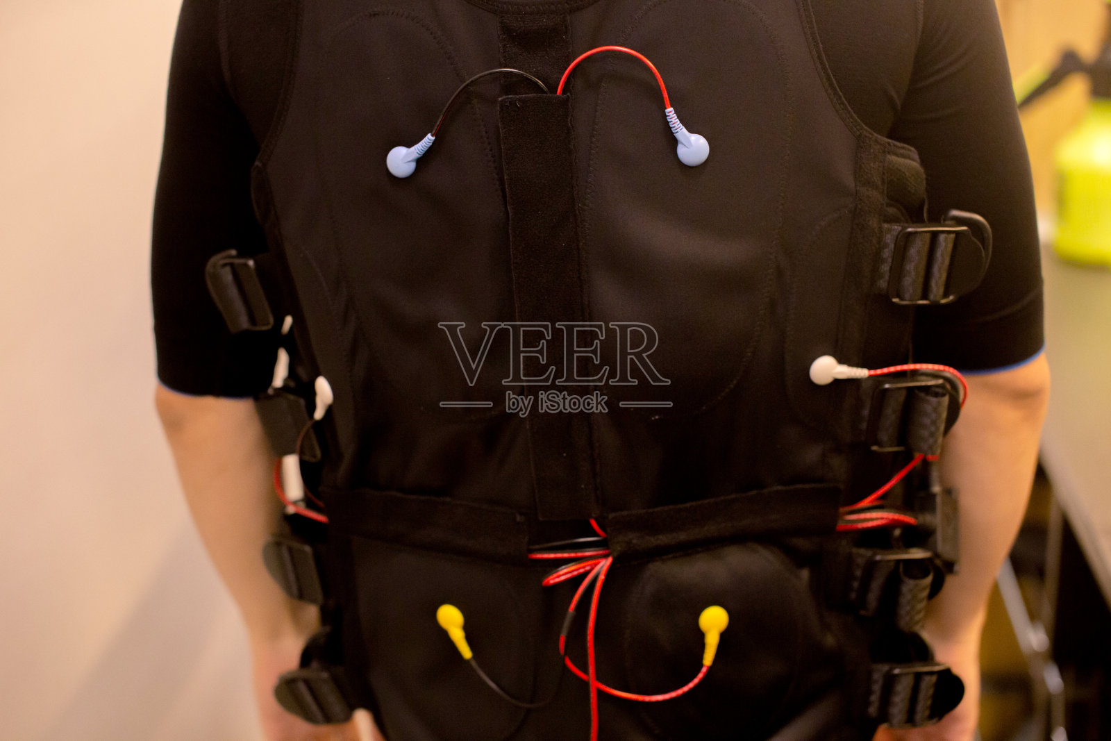 特写的健康男子在黑色全身西装ems培训和肌肉电极技术。照片摄影图片