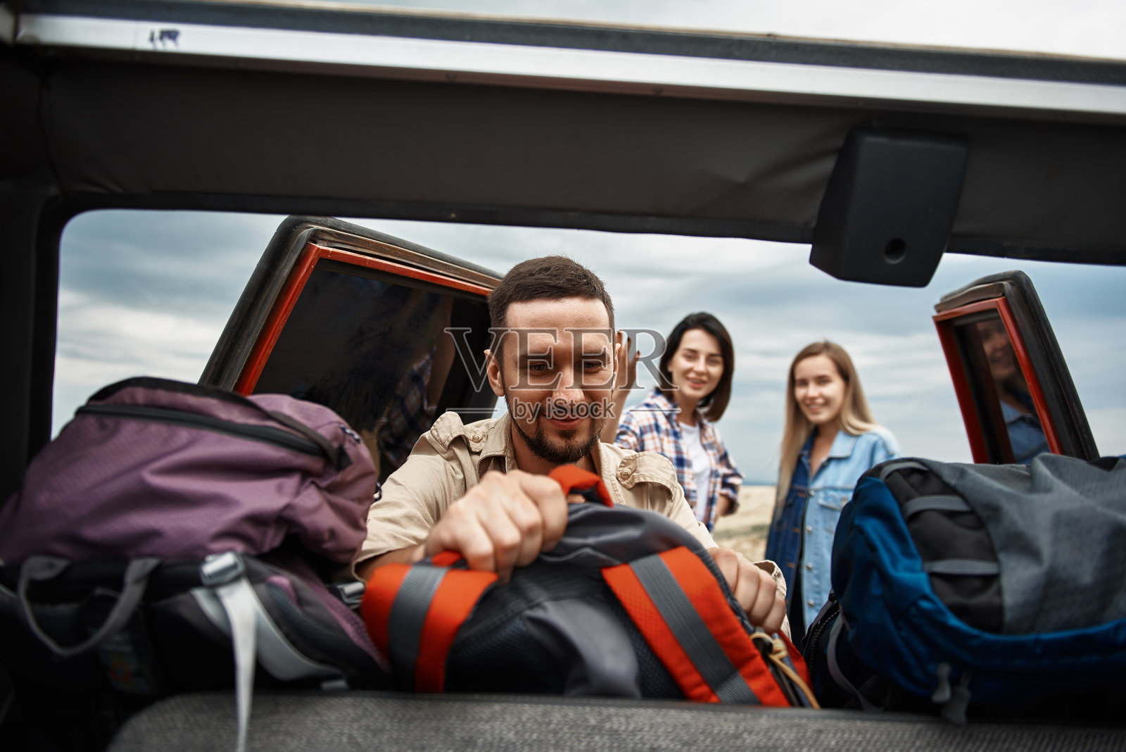 正从车里拿背包的大胡子照片摄影图片