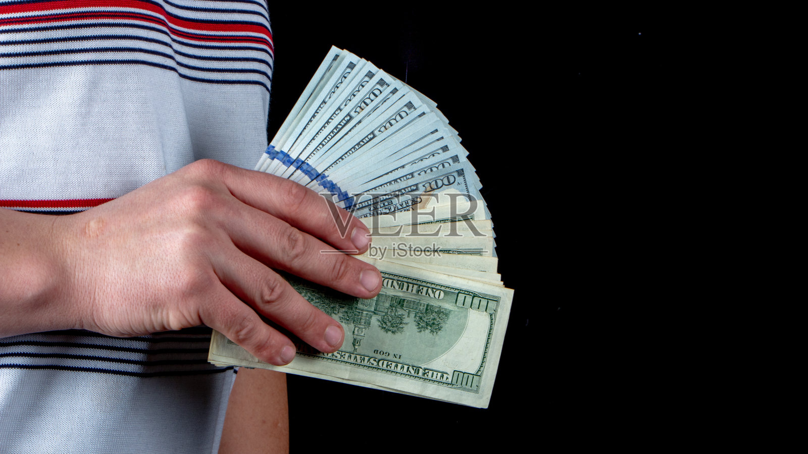 黑色背景下男性手中的美元扇子照片摄影图片