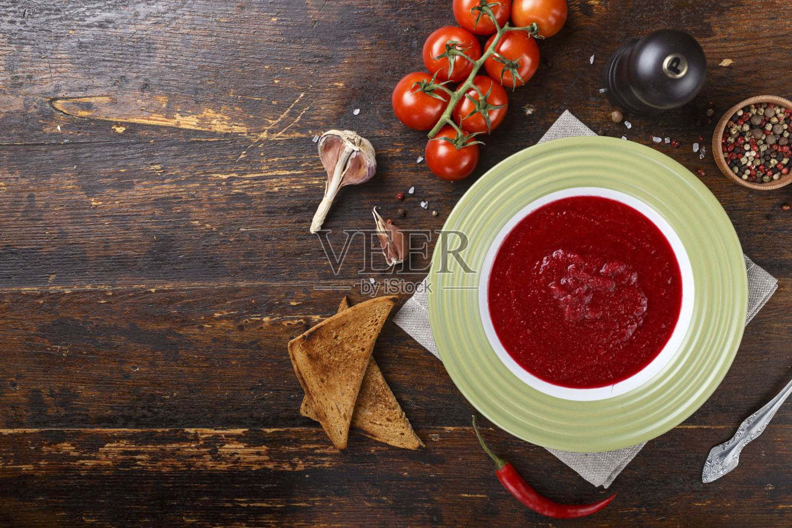 传统的意大利番茄凉菜汤放在木桌上的盘子里。照片摄影图片