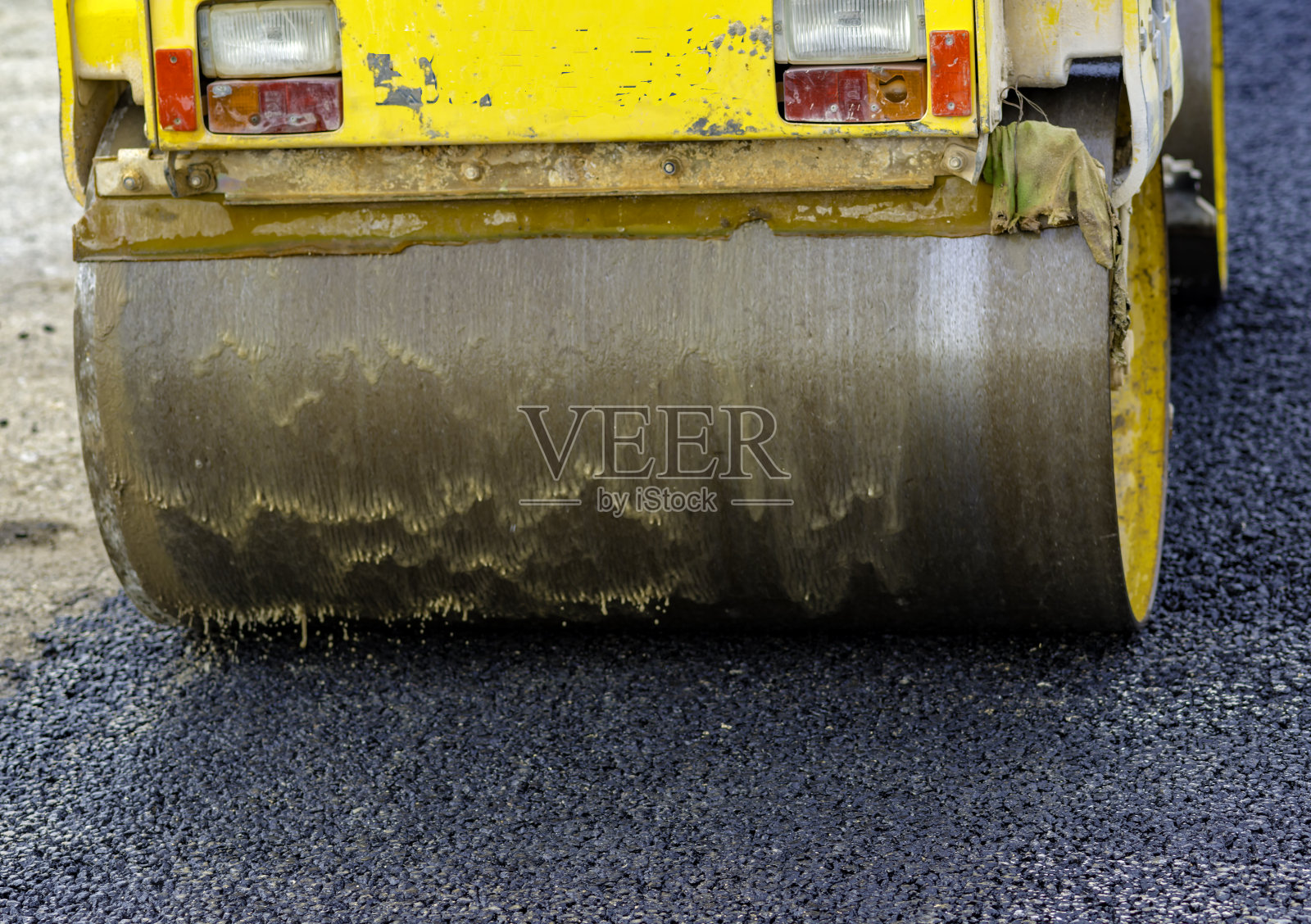 特写压扁机压扁沥青。照片摄影图片