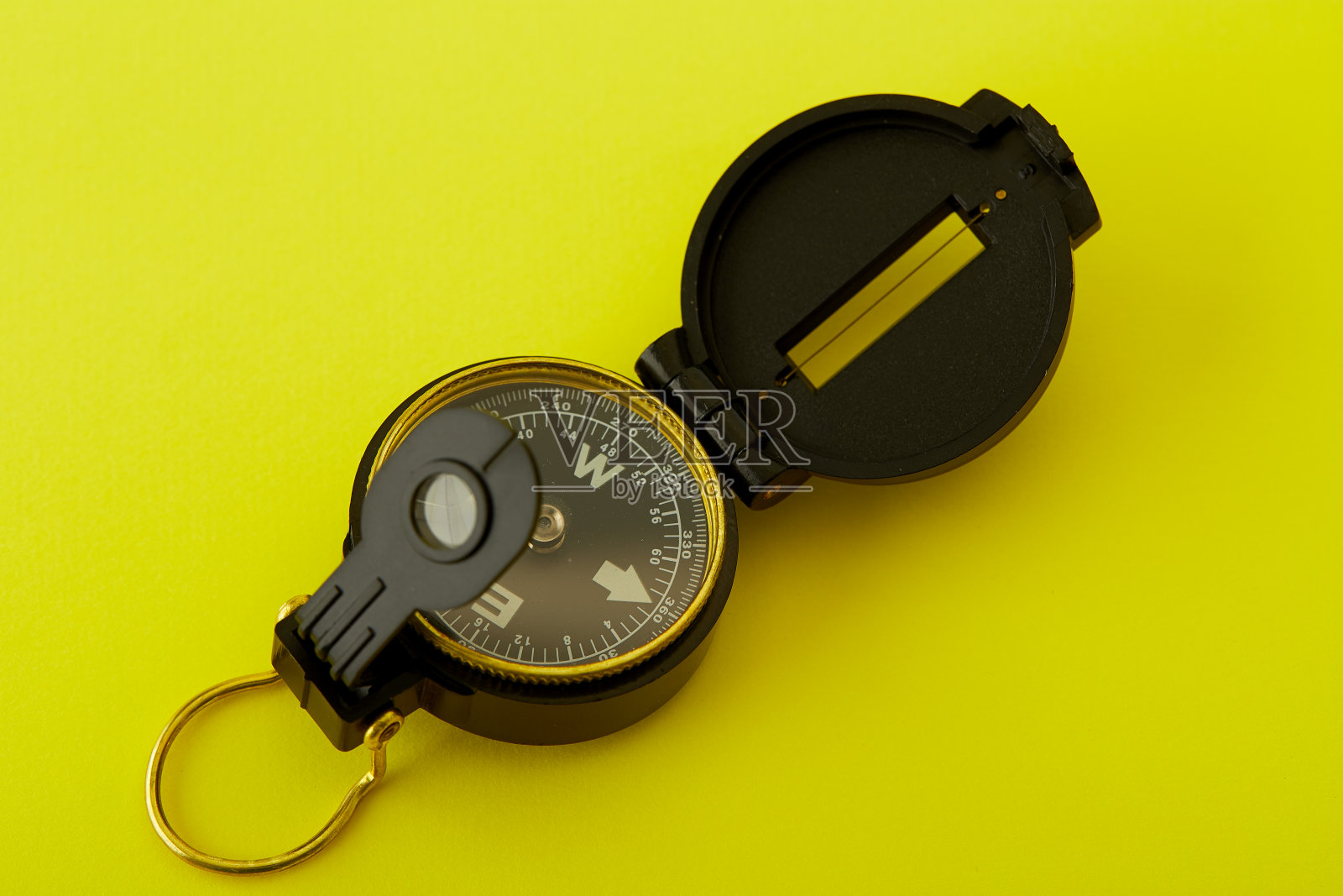 明亮的黄色背景上的最小指南针,旅行的概念照片摄影图片