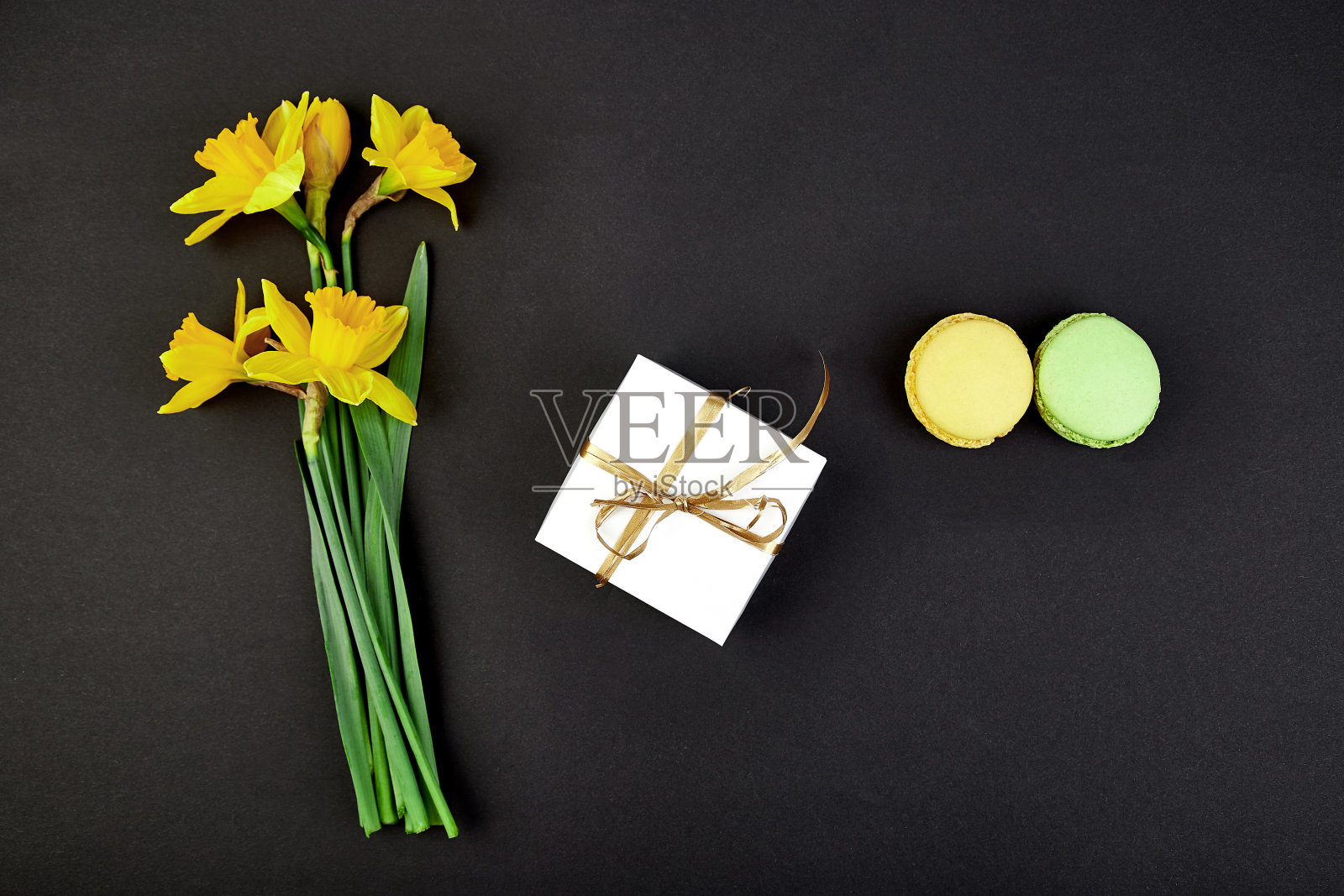 花束鲜花、水仙礼物、糖果或蛋糕马卡龙。照片摄影图片