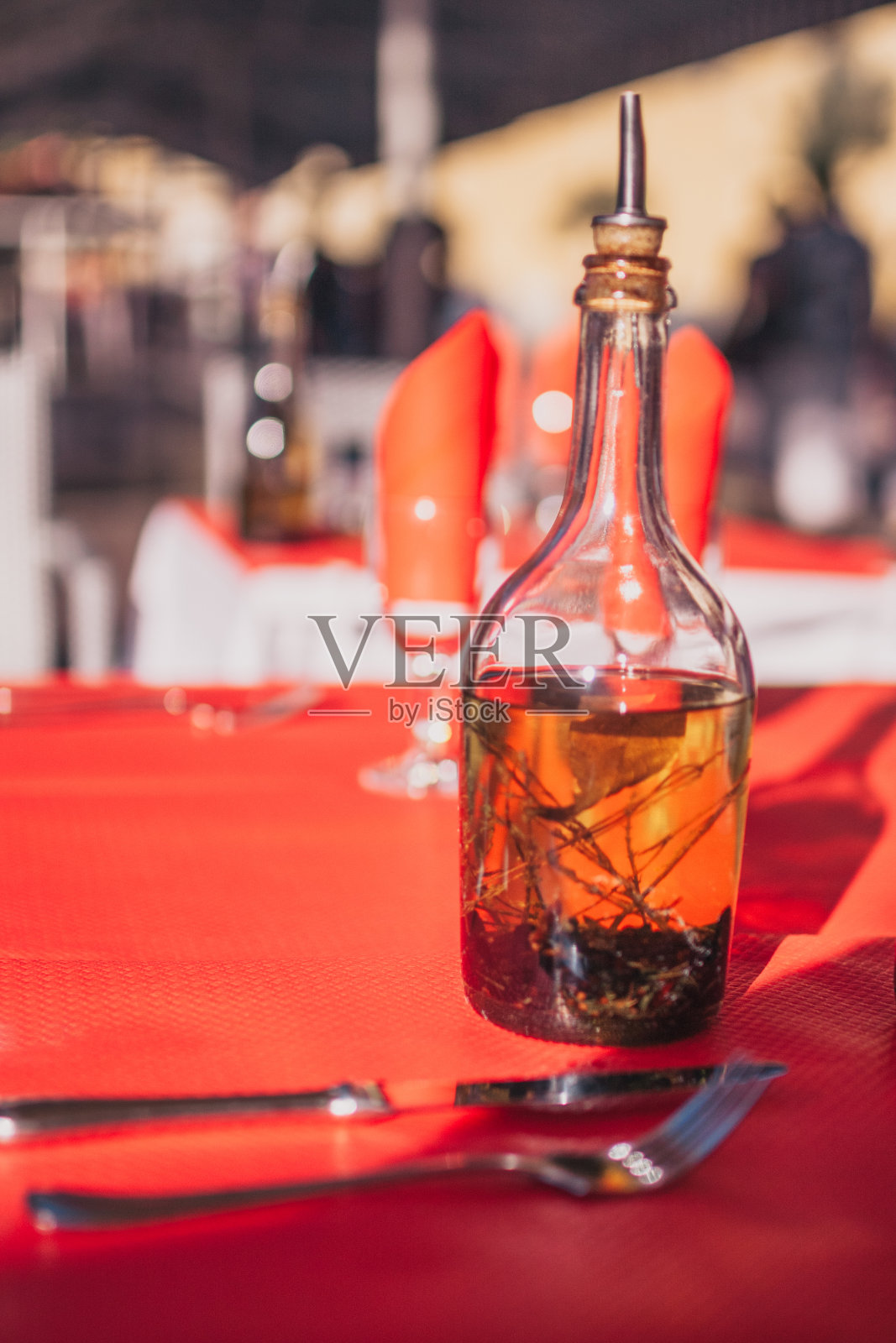 餐厅桌子上的玻璃瓶里的橄榄油照片摄影图片