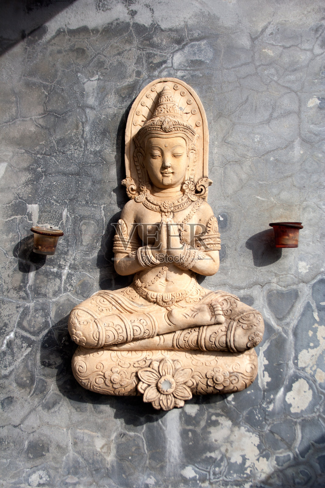 坐着祈祷的佛像和小烛台照片摄影图片