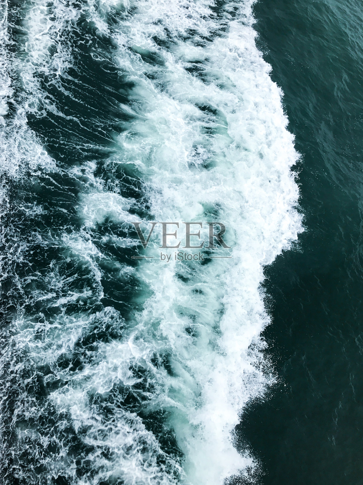 深蓝色的波涛汹涌的海面,白色的泡沫和波浪照片摄影图片