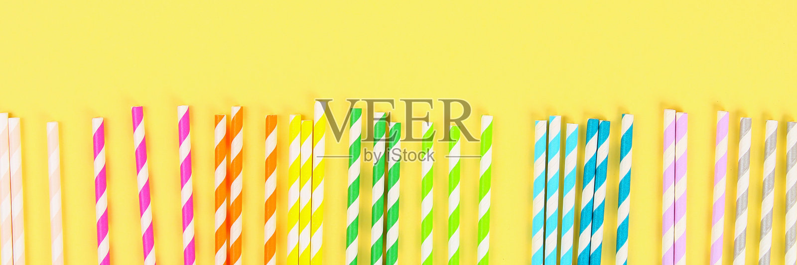 多色草纸管在明亮的黄色柔和的背景。俯视图,复制空间。照片摄影图片