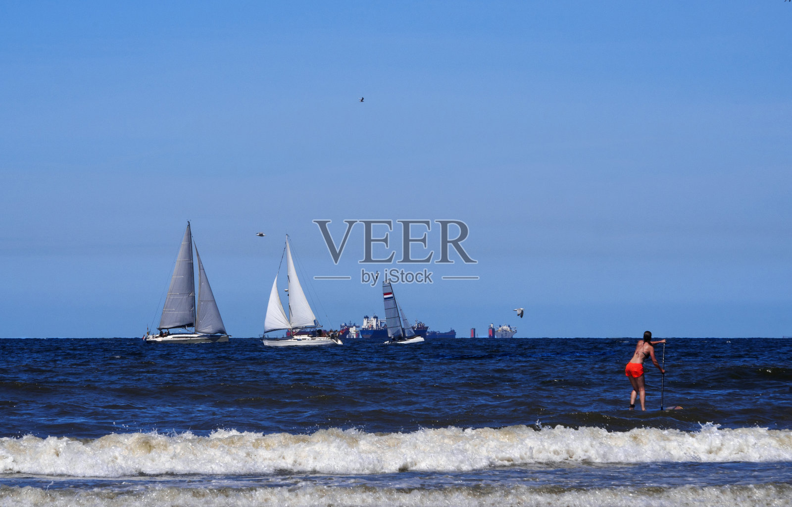 一个阳光明媚的夏日,北海的斯赫弗宁根海滩上的游艇和超级冲浪者照片摄影图片