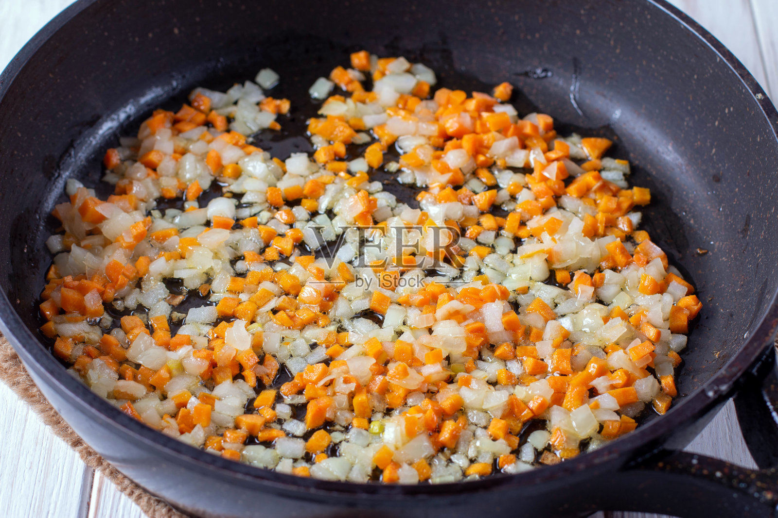 洋葱圈和胡萝卜在热锅里炖照片摄影图片