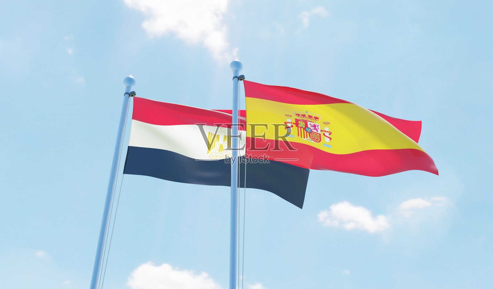 西班牙和埃及,两面旗帜在蓝天下飘扬照片摄影图片