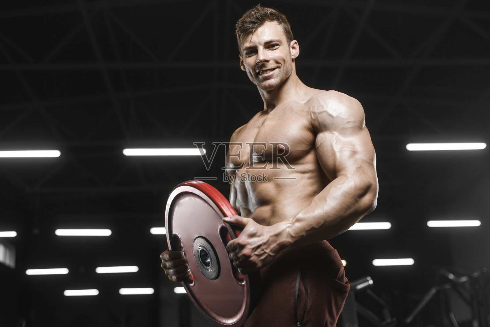 英俊强壮的运动员男子抽肌肉锻炼杠铃卷曲健身的概念背景照片摄影图片