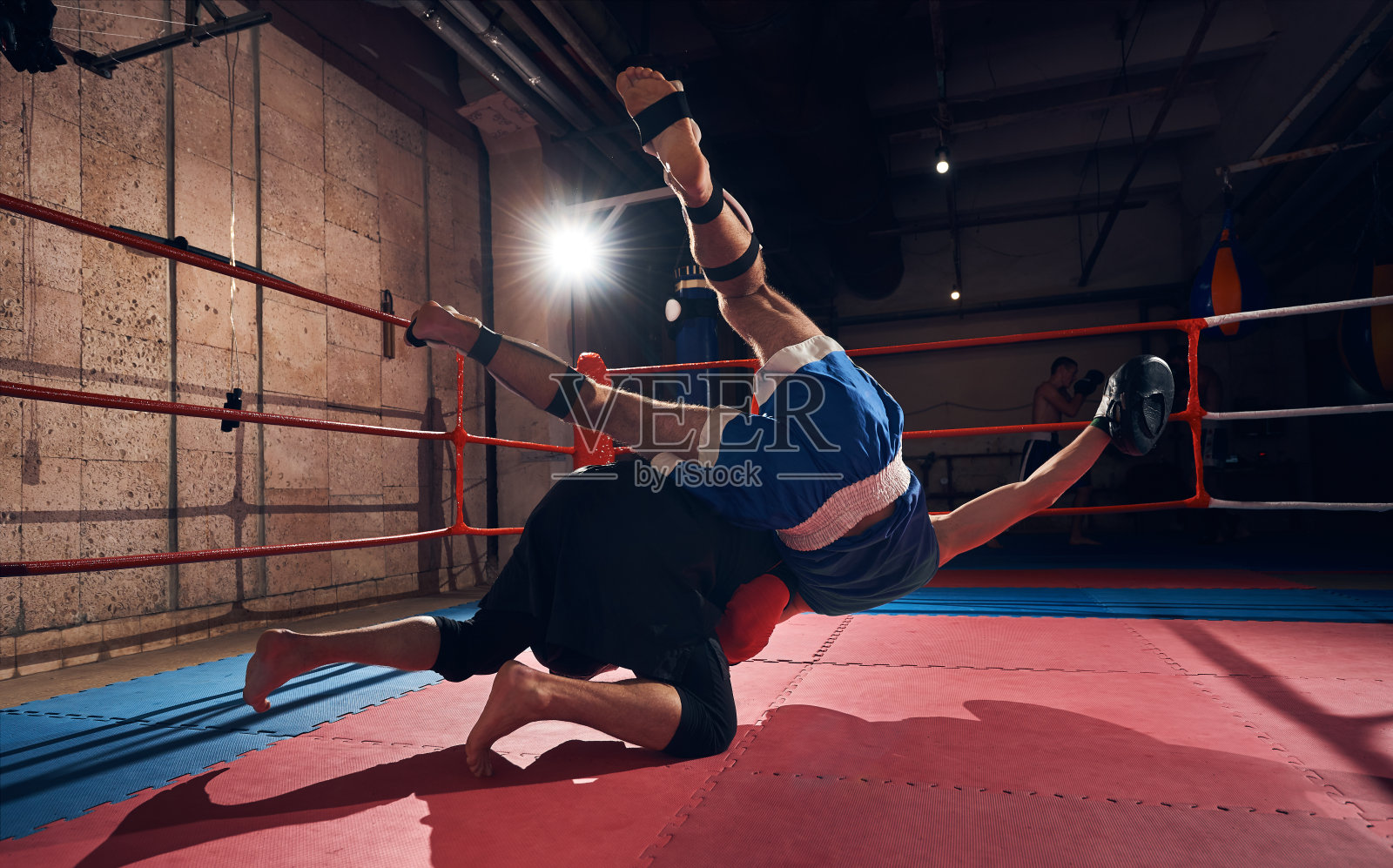 拳击手在健身俱乐部的拳击场上训练跆拳道照片摄影图片