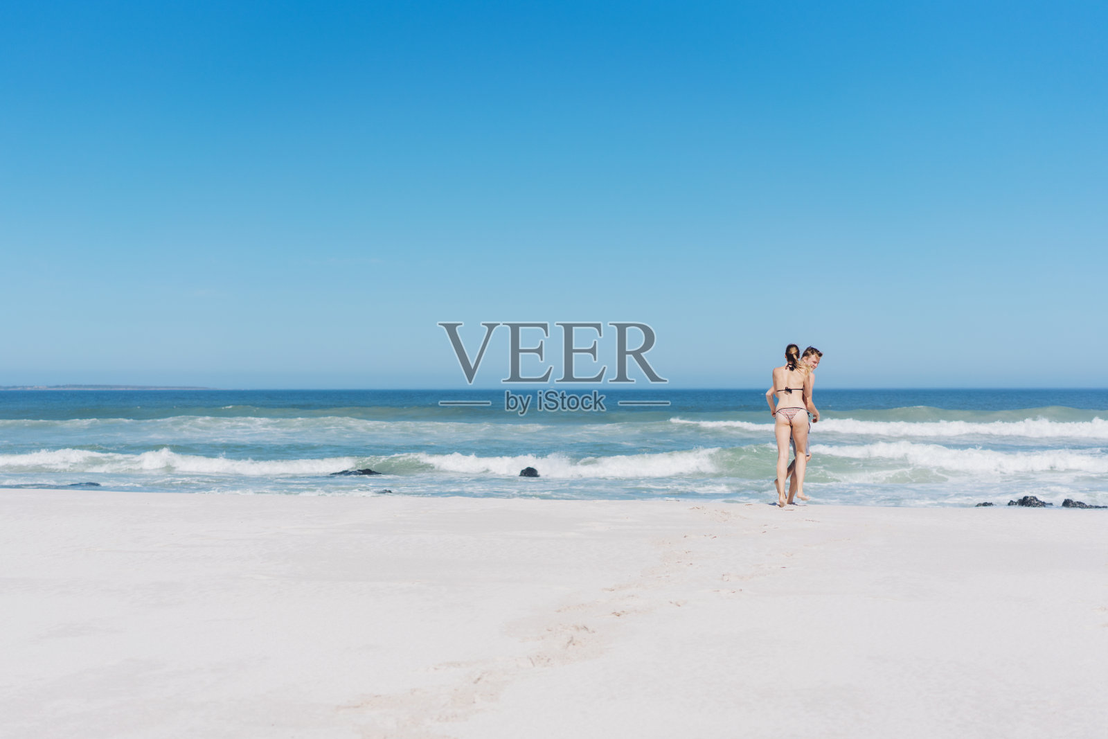 一对穿着泳衣的年轻夫妇下水了照片摄影图片