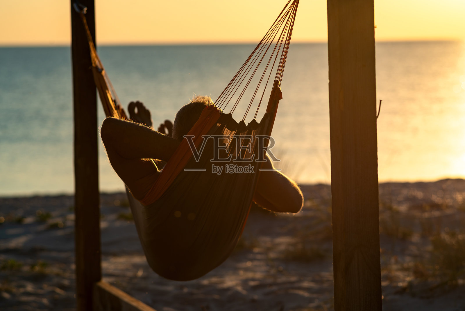 一名男子在废弃的平房阳台上的吊床上休息照片摄影图片