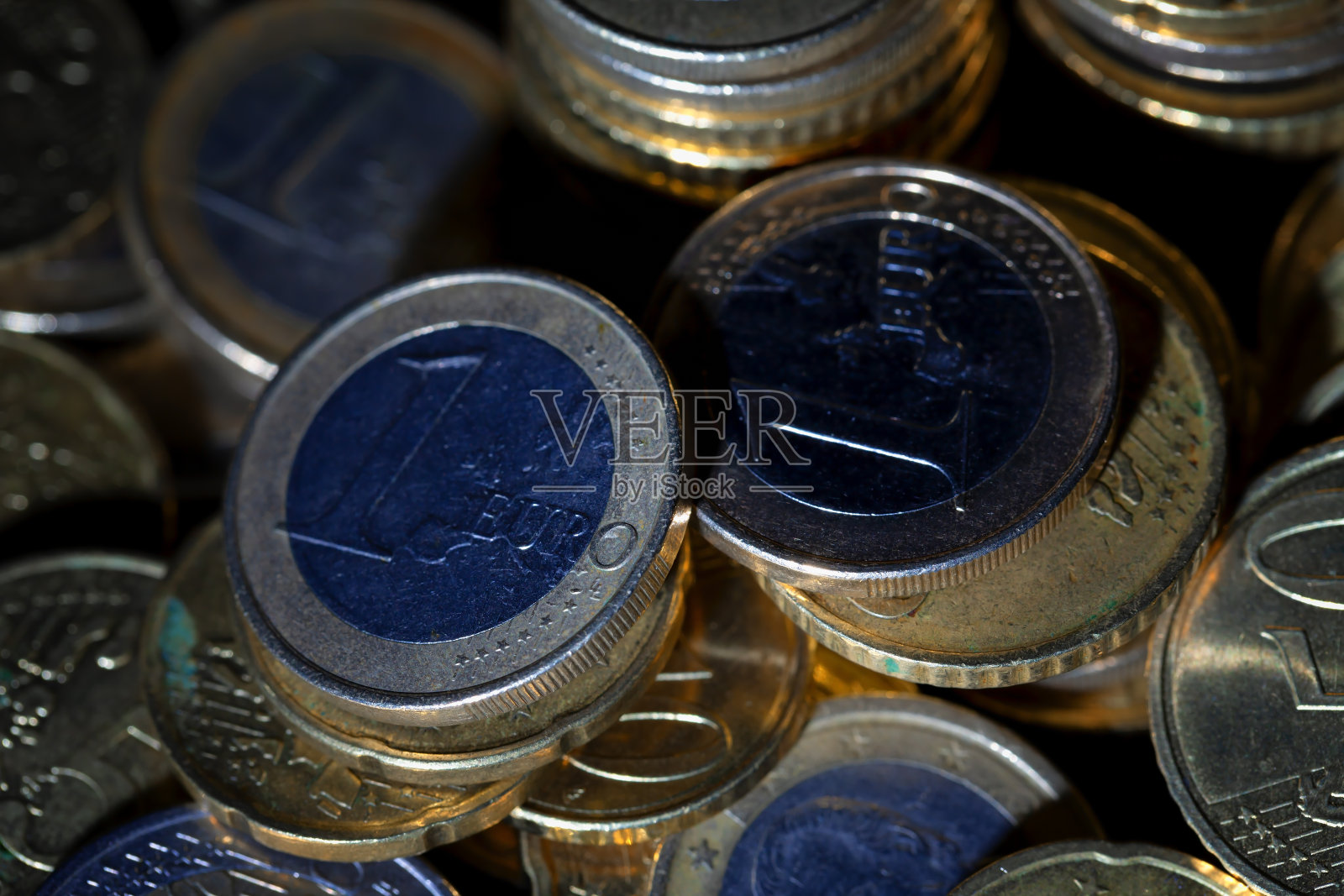 黑色背景上有很多欧元硬币和美分照片摄影图片