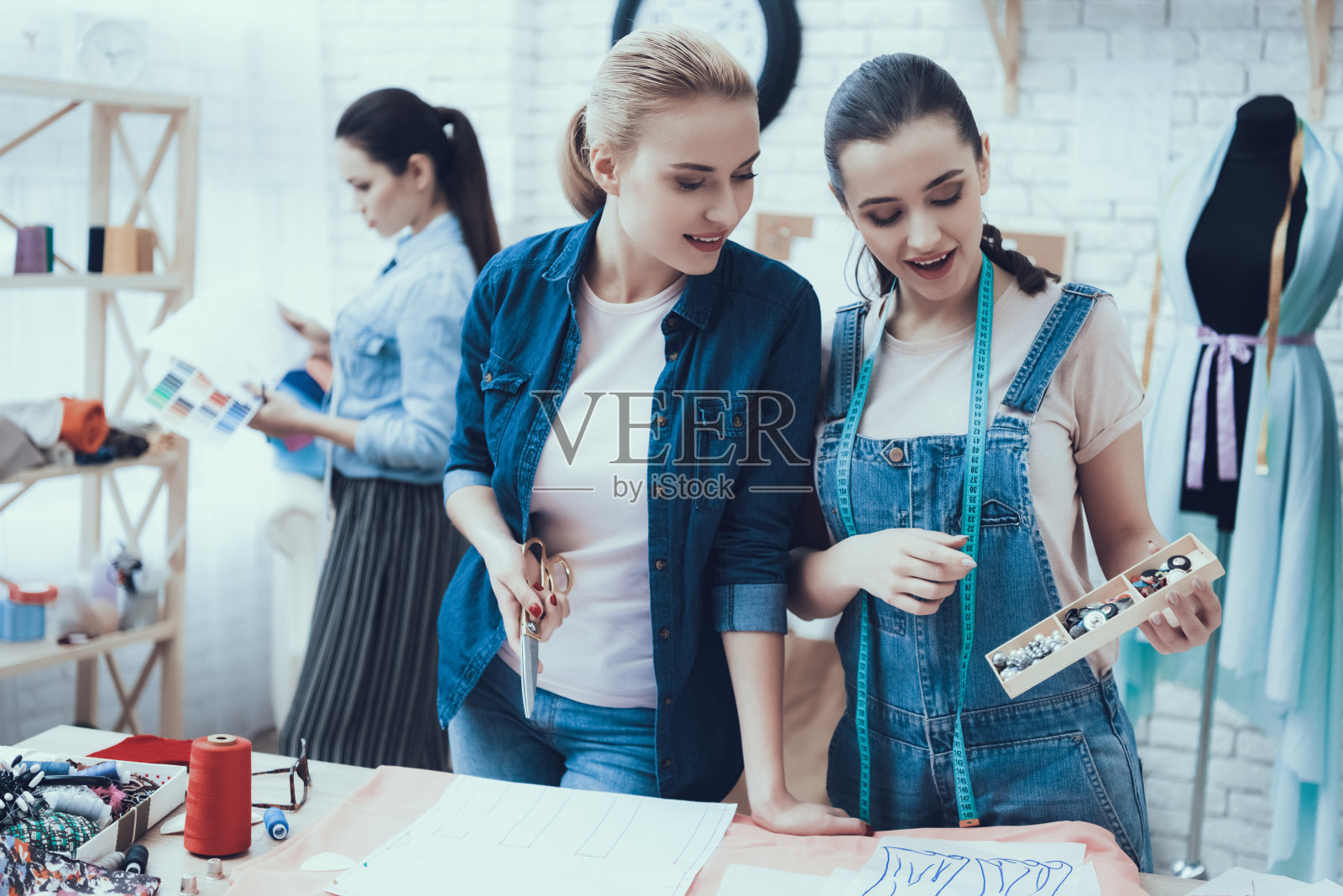 女孩拿着剪刀,看着材料照片摄影图片