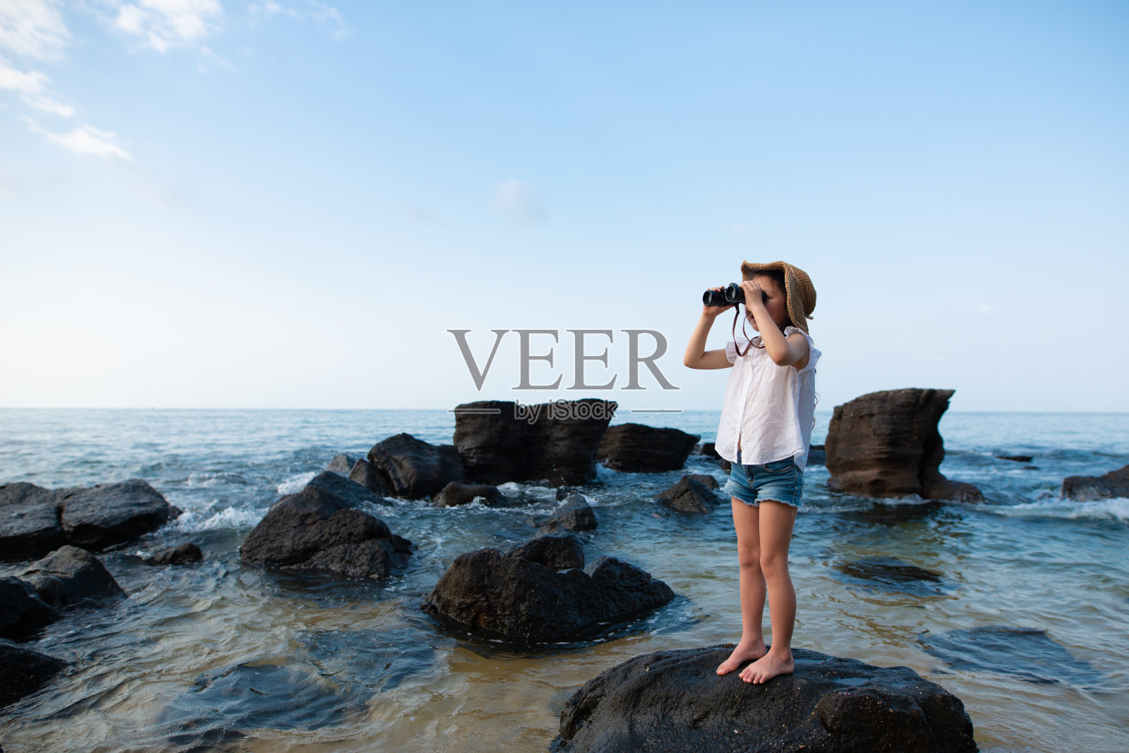 女孩在海里用双筒望远镜照片摄影图片
