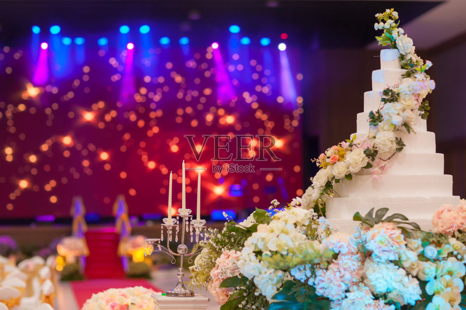 婚礼蛋糕上的花靠近婚礼蜡烛。照片摄影图片