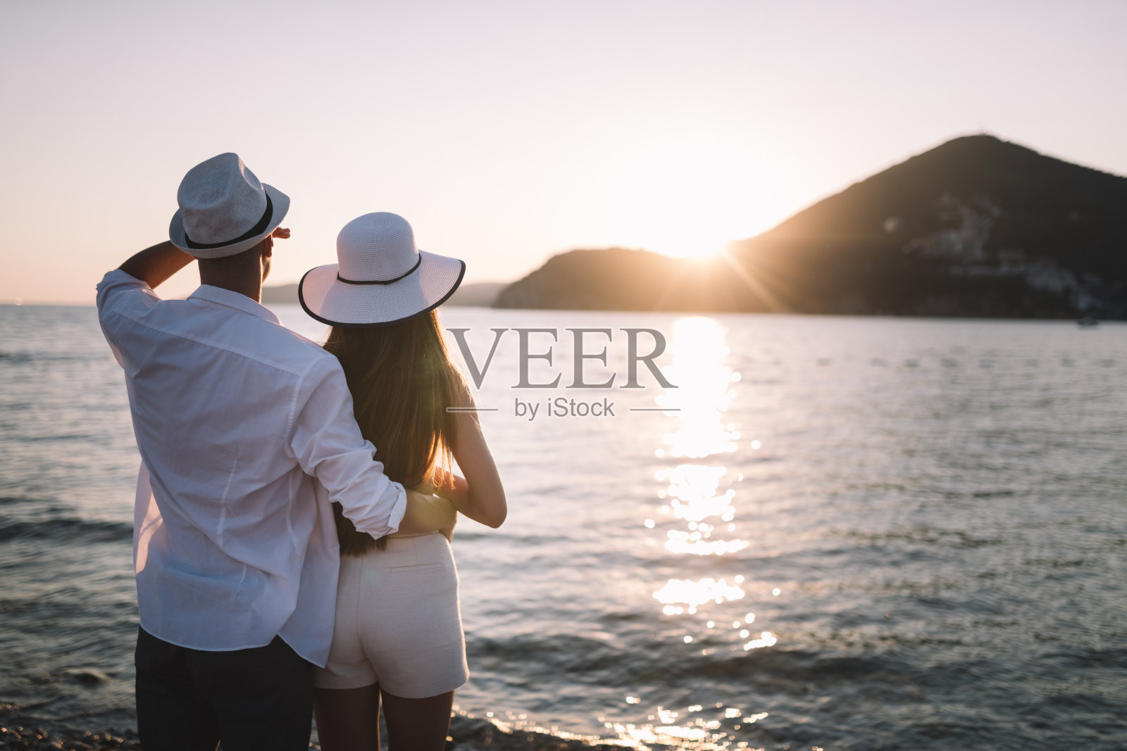 美丽的年轻人在爱情中漫步。一对夫妇在海滩上的日落夏季度假照片摄影图片