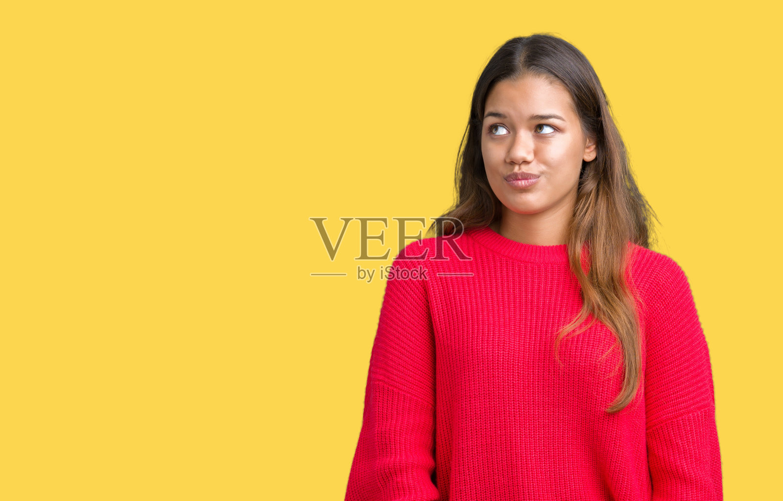 年轻美丽的黑发女人穿着红色的冬季毛衣在孤立的背景下,使鱼脸与嘴唇,疯狂和滑稽的手势。有趣的表情。照片摄影图片