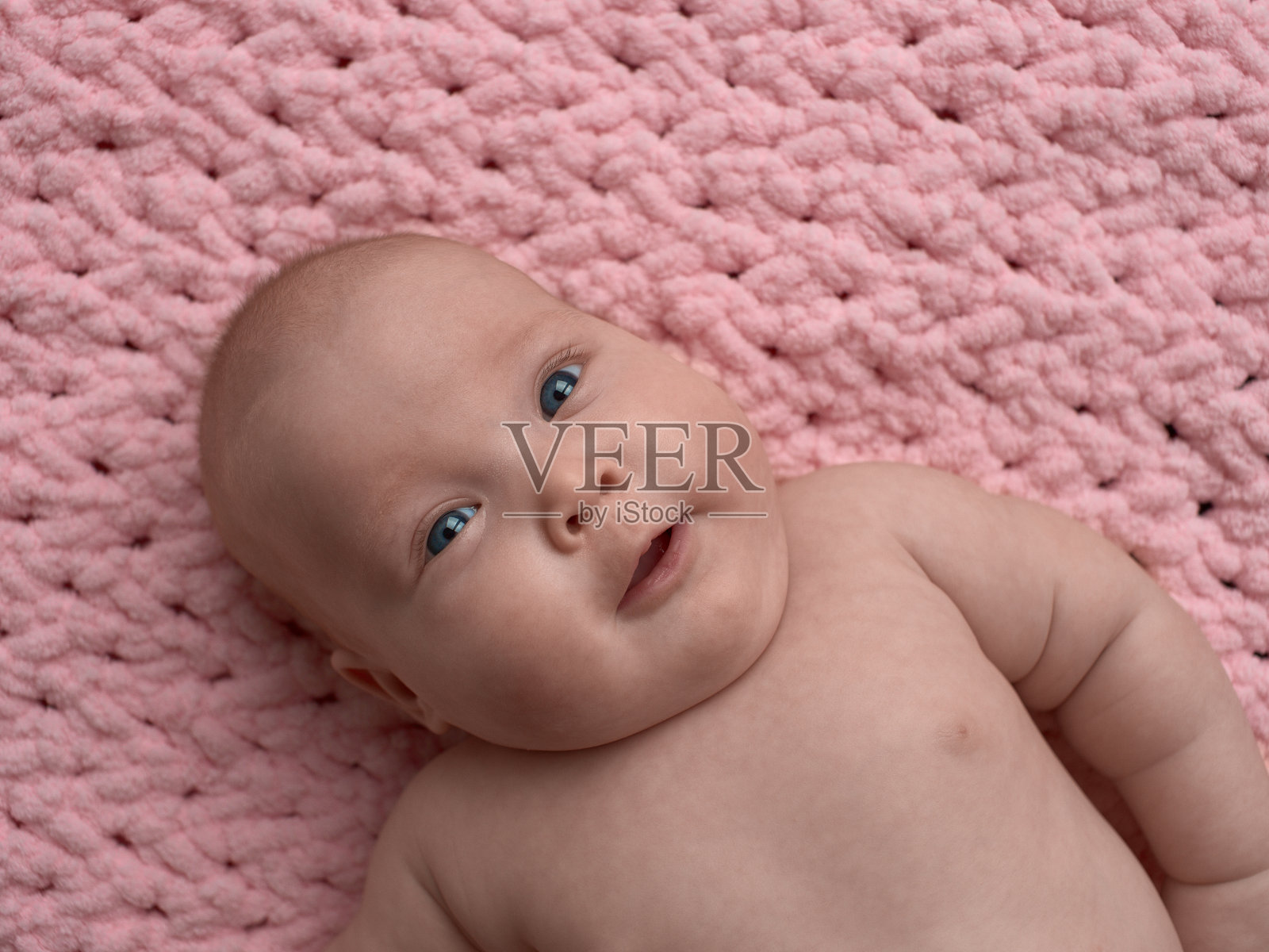 心满意足的婴儿躺在床上。照片摄影图片