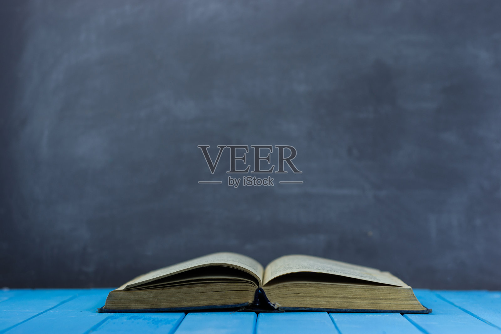 圣经和十字架放在蓝色的木桌上。美丽的背景。宗教的概念照片摄影图片