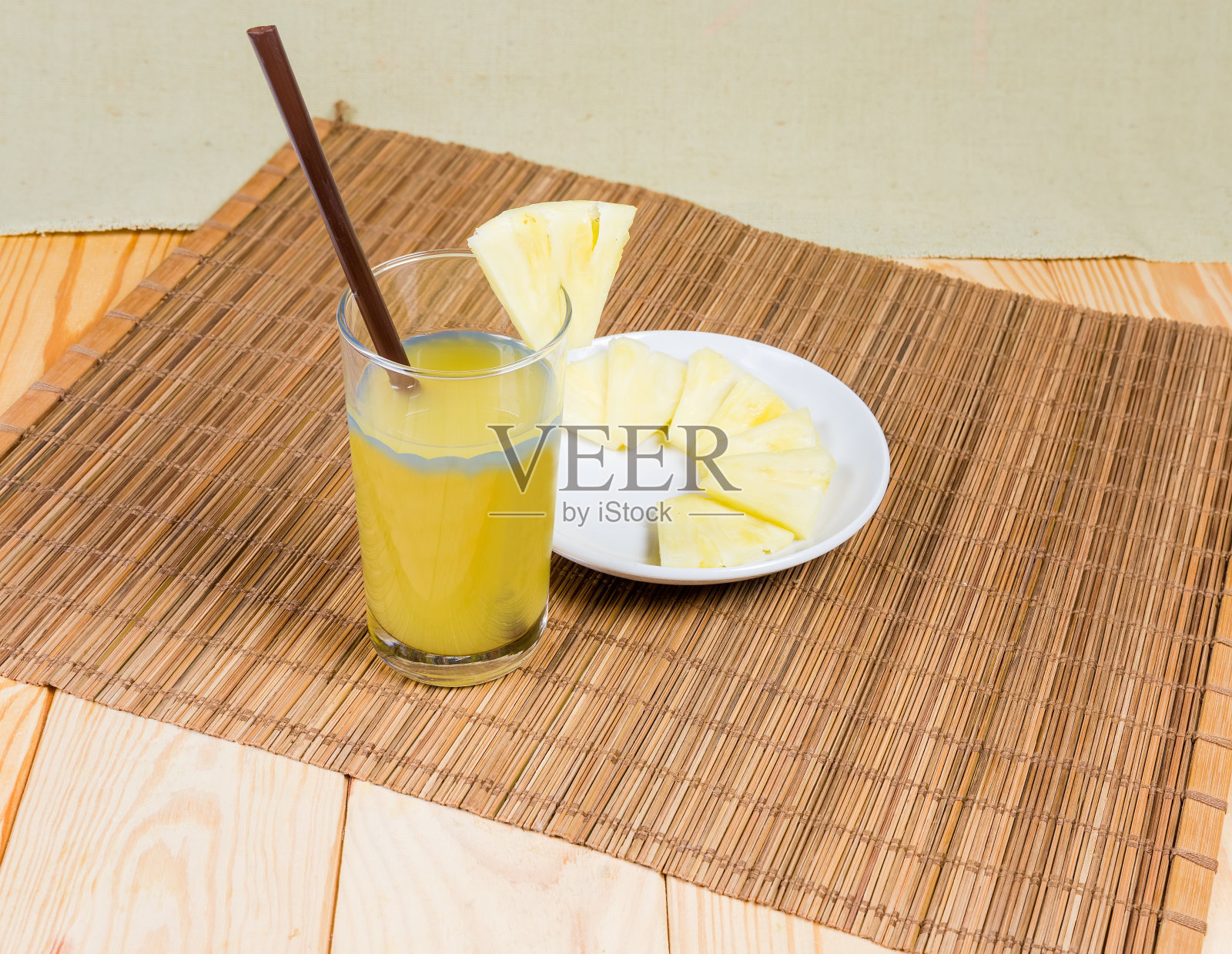 菠萝汁在玻璃杯中,用吸管,新鲜的菠萝片照片摄影图片