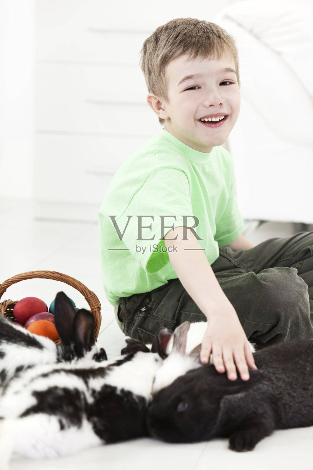 篮子里装着兔子和复活节彩蛋的小男孩照片摄影图片