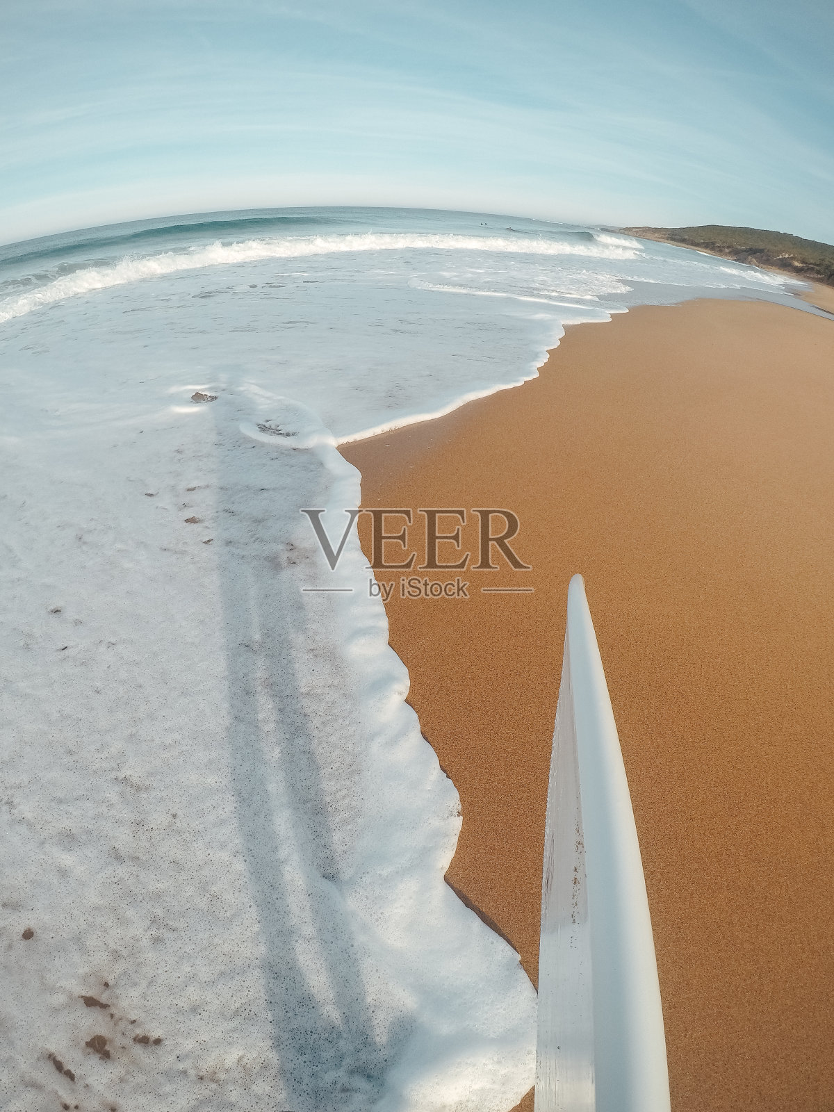 冲浪者与一个冲浪板在沙滩上的观点照片摄影图片