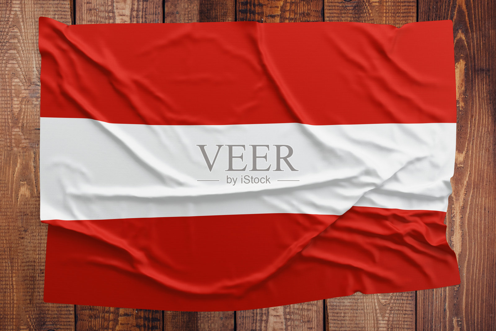 木桌背景上是奥地利国旗。皱巴巴的奥地利国旗俯视图。照片摄影图片