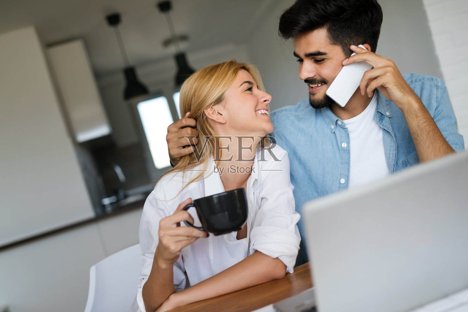 一对年轻漂亮的夫妇喝着咖啡,互相看着对方照片摄影图片