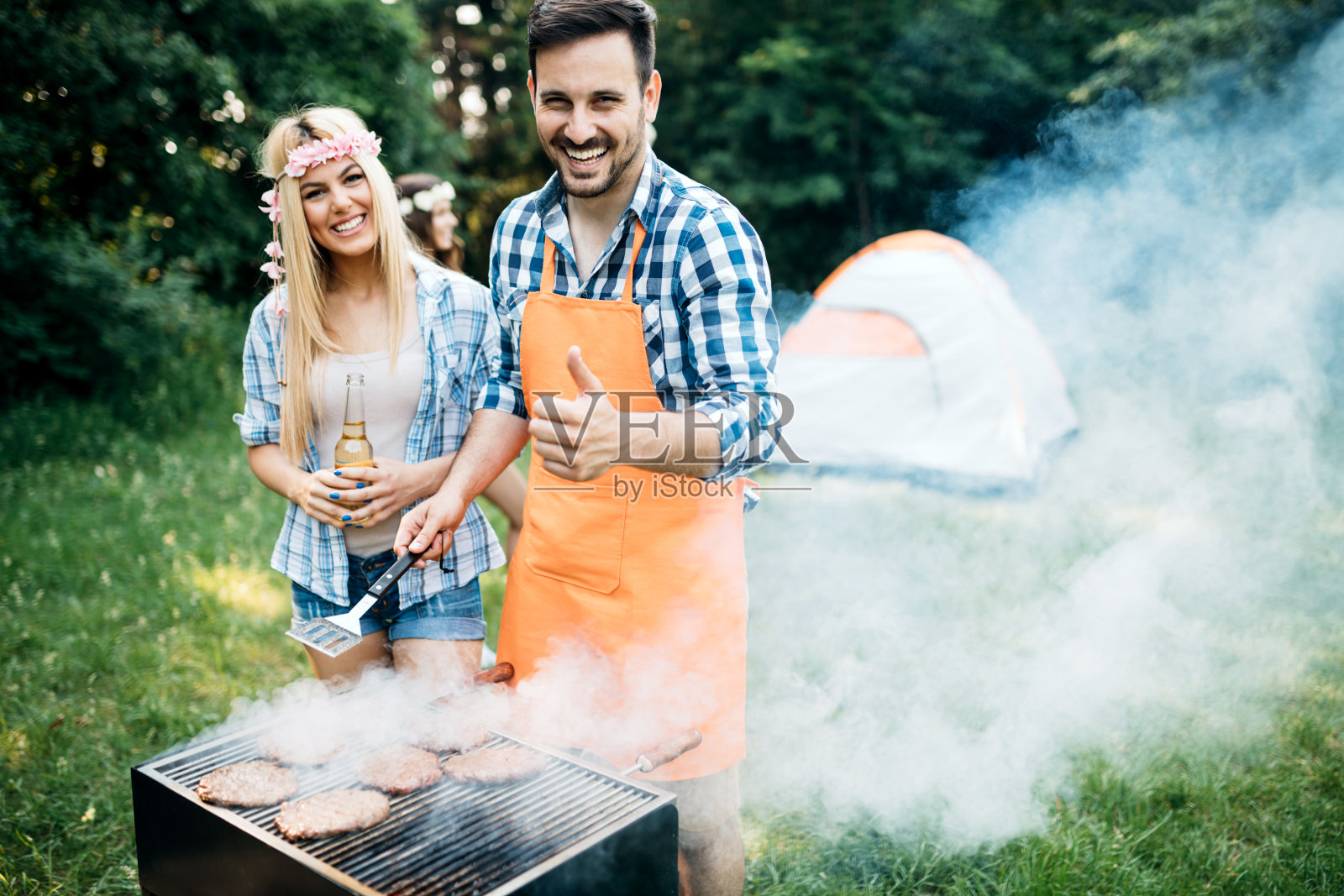 一群快乐的朋友在森林里举行烧烤聚会照片摄影图片
