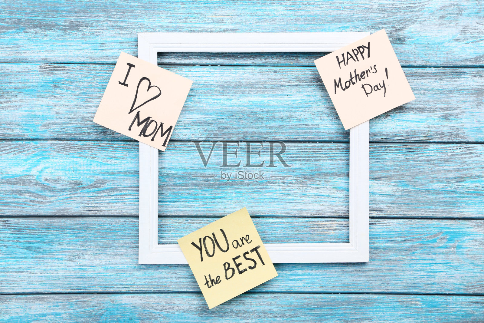 蓝色木桌上有相框的贺卡照片摄影图片