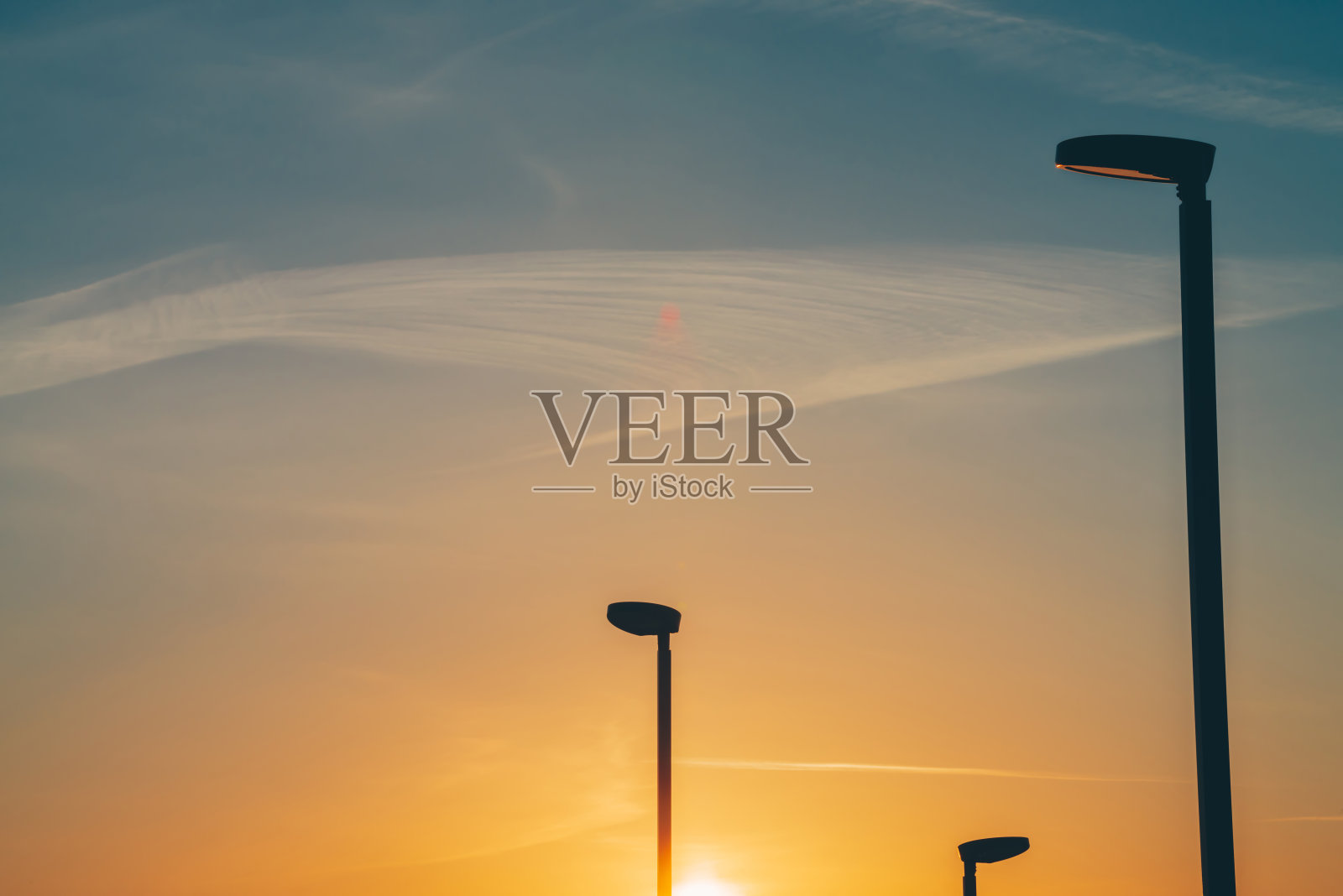 特别灯笼,以防止日落时的光污染。温暖的自然背景的天空日出梯度。黎明时分,街灯和柱子的剪影。极简主义的黎明前城市景观。照片摄影图片