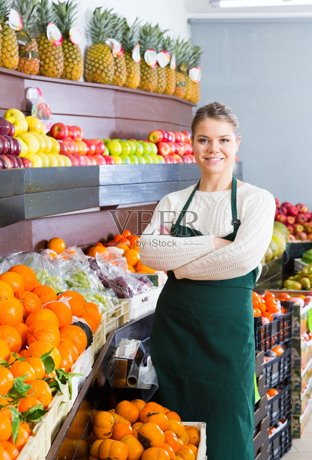 穿着围裙卖新鲜橙子的漂亮女人照片摄影图片