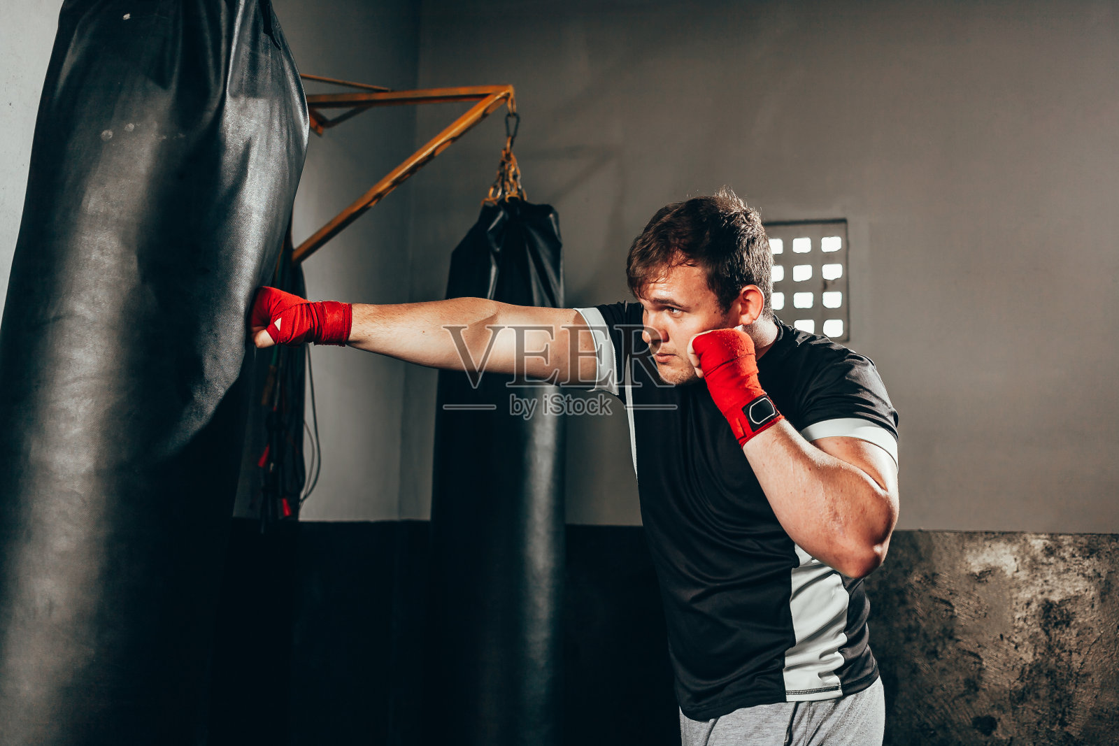 拳击手在健身房的重包里训练照片摄影图片