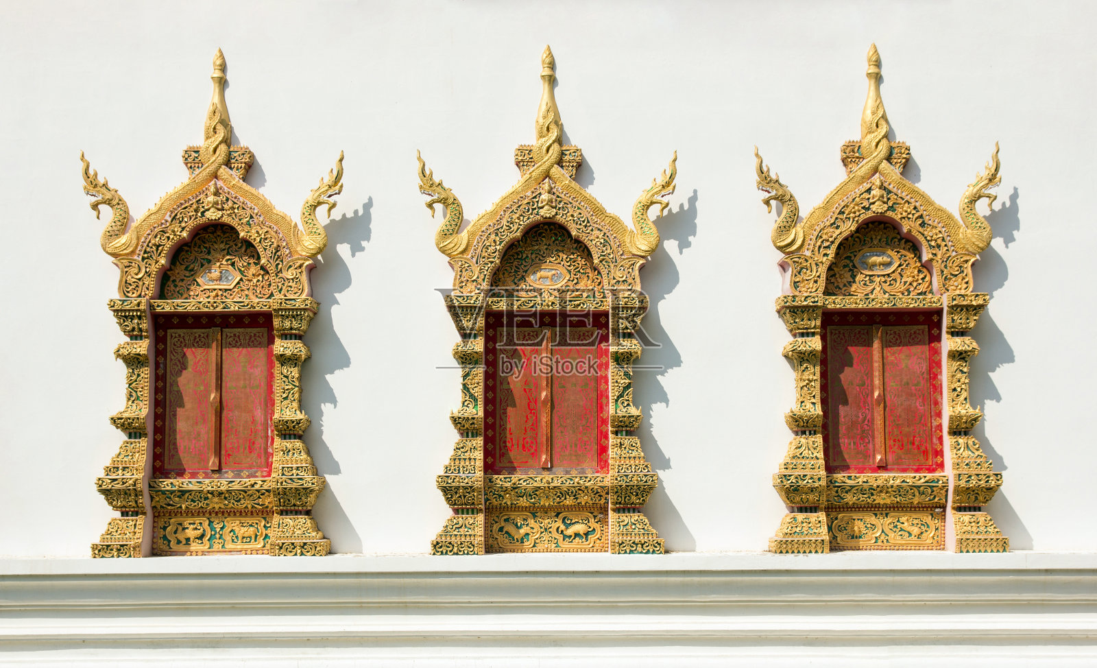 金色的窗框在白色的混凝土墙上的寺庙。泰式装饰的图案照片摄影图片