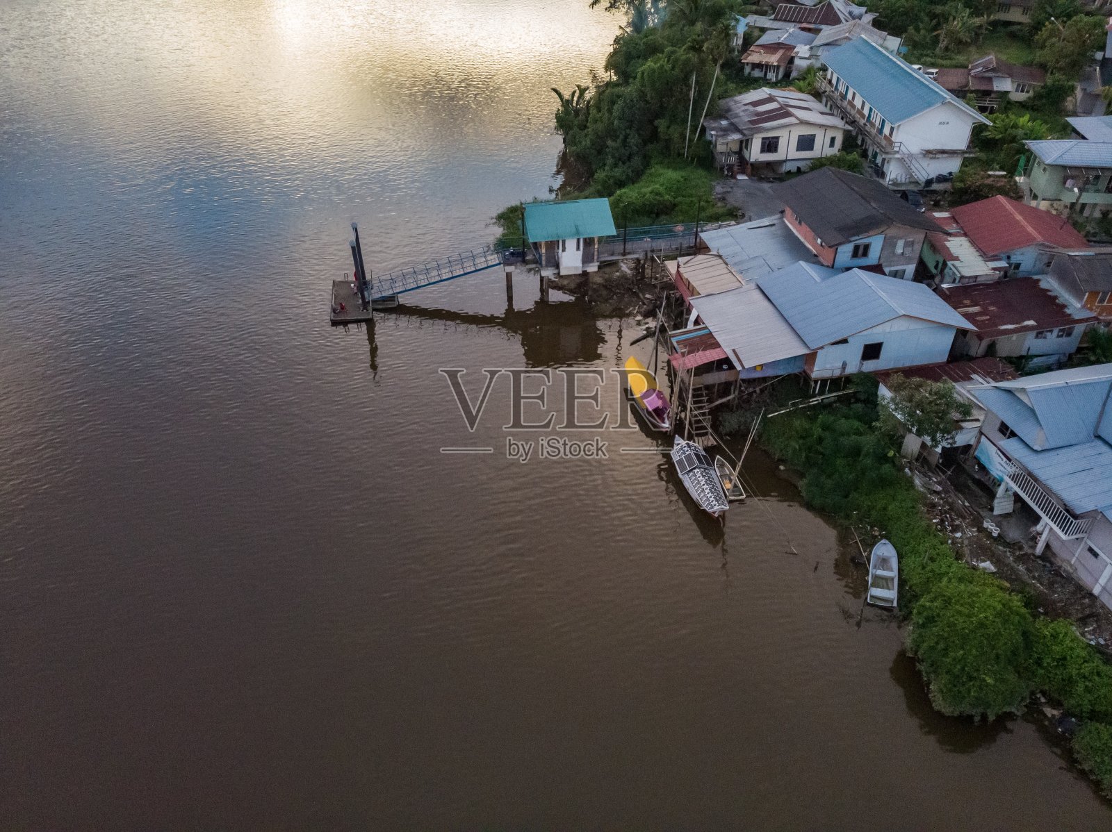夕阳下的马来西亚古晋沙捞越河,背景是塞拉比山照片摄影图片