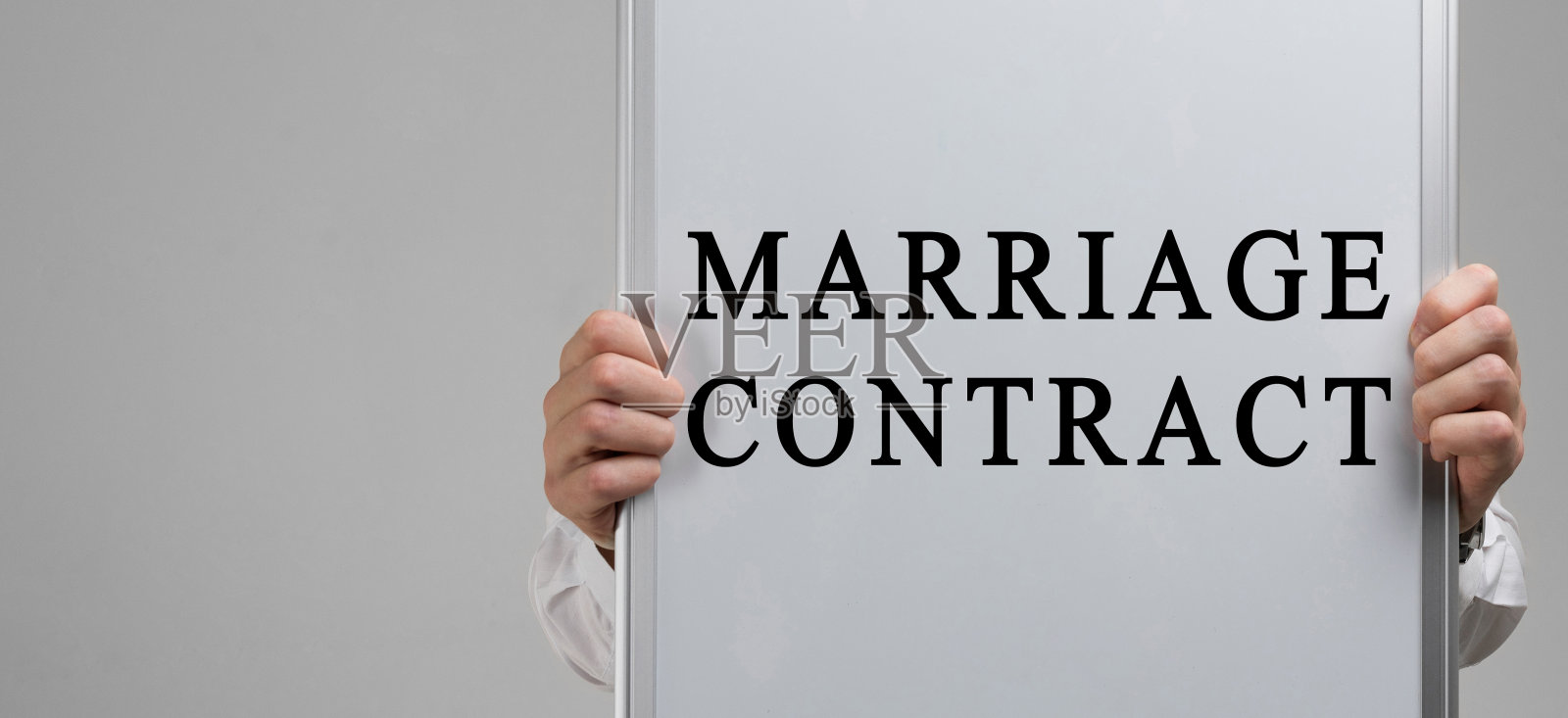 浅色背景下男人手持婚姻合同海报照片摄影图片