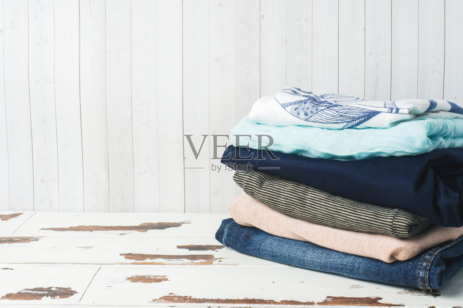 一堆女人的衣服放在白板上,还有一份空白。照片摄影图片