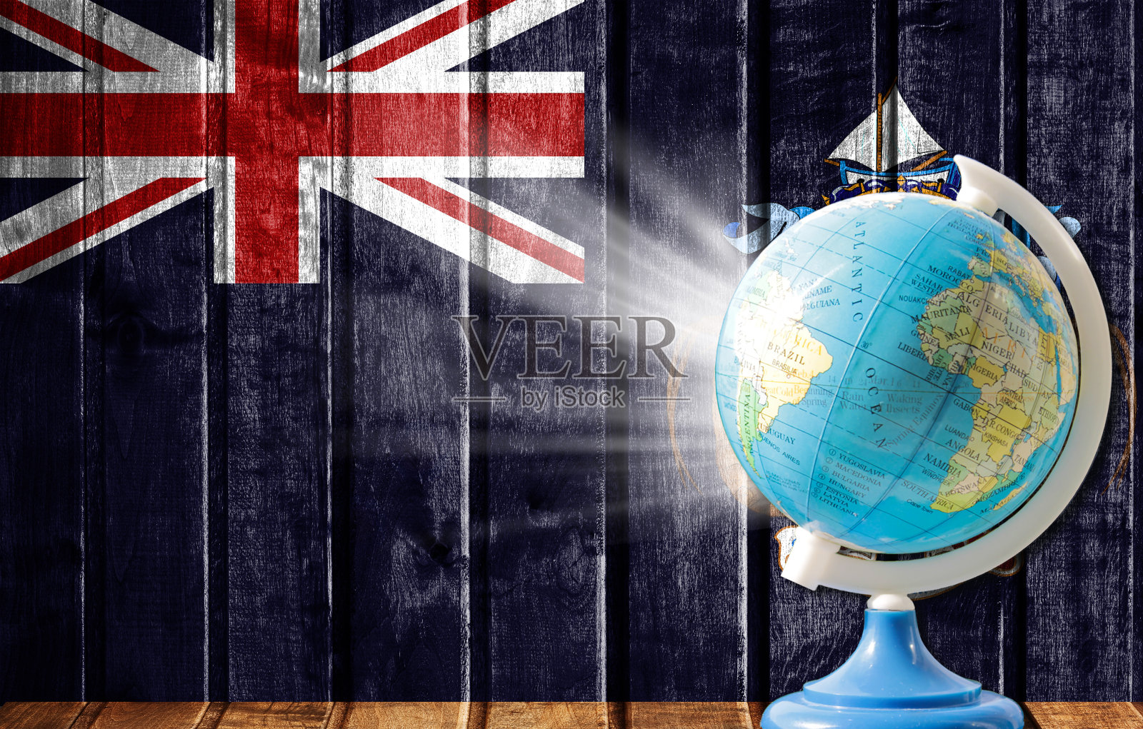 以木质背景为背景的世界地图,以特里斯坦-达库尼亚岛的旗帜为背景。国外旅游和休闲的概念。照片摄影图片