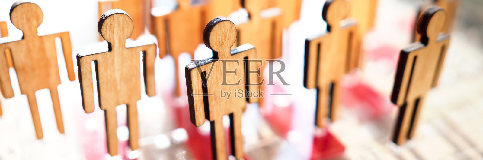 小小的木制玩具人物形象排成一排照片摄影图片