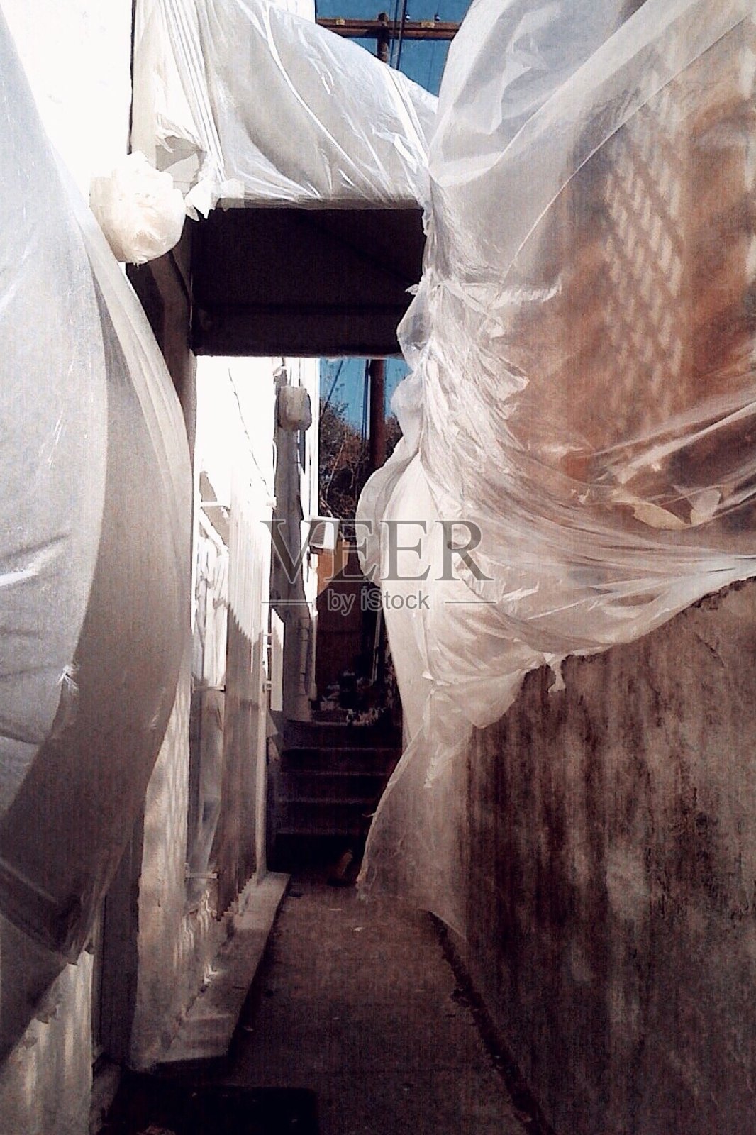 在狭窄的小巷里,塑料覆盖物随风飘动照片摄影图片