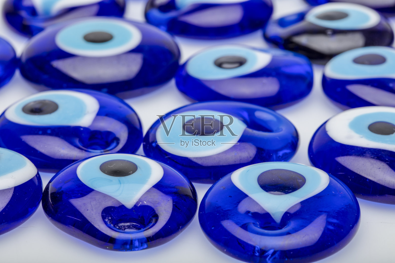 许多传统的邪恶眼睛护身符的背景。白色背景上的土耳其玻璃眼睛。照片摄影图片