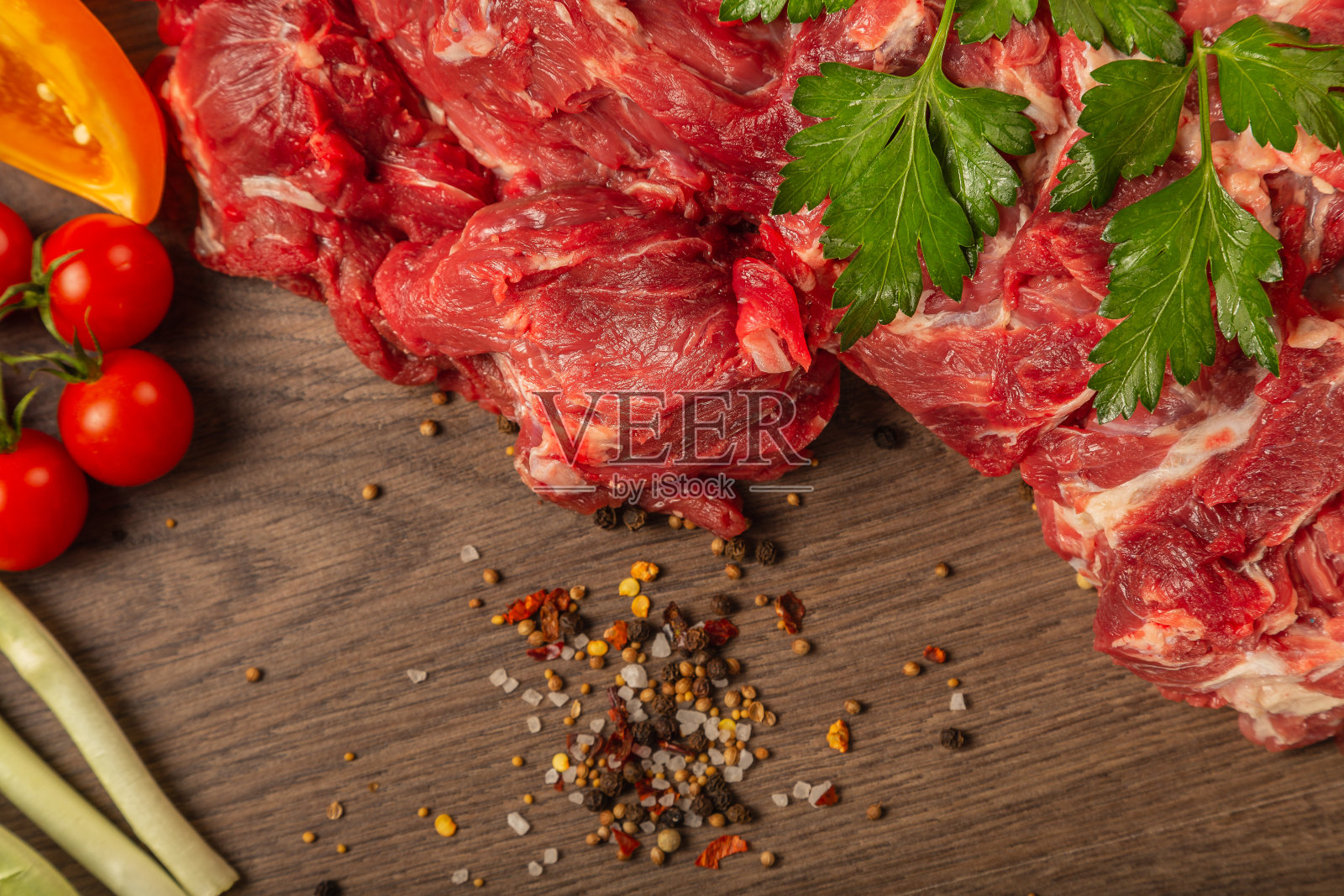 木背景上的生牛肉配上香料和蔬菜照片摄影图片